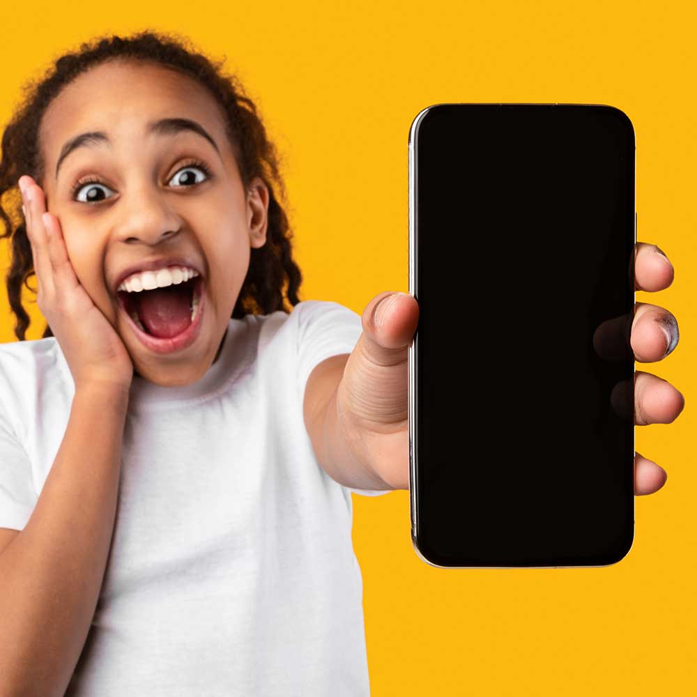 An excited teenager holding a smartphone.